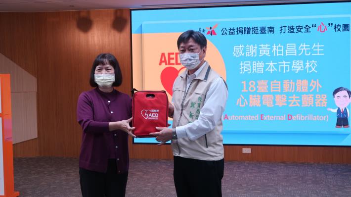 市民黃柏昌母親陳雪(左)代表捐贈AED給本市國中小.JPG