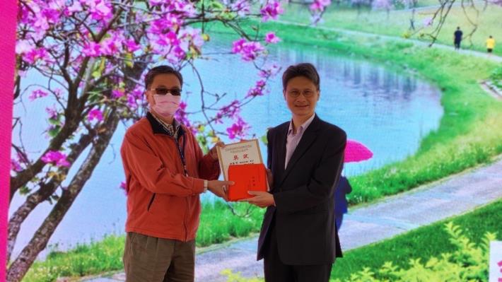 南科管理局局長蘇振綱贈與南科新市全國攝影比賽第一名洪榮宗先生獎狀及獎品